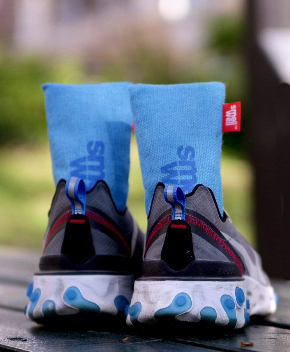 A pair of SmellWell Sensitive XL - Blue sticking out of a pair of running shoes