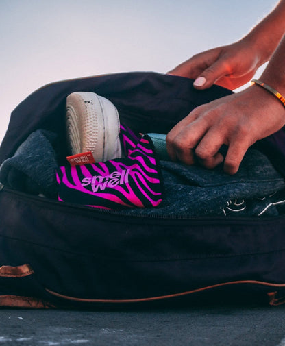 SmellWell Active - Pink Zebra freshener inserts lying in a bag with dirty gym clothes